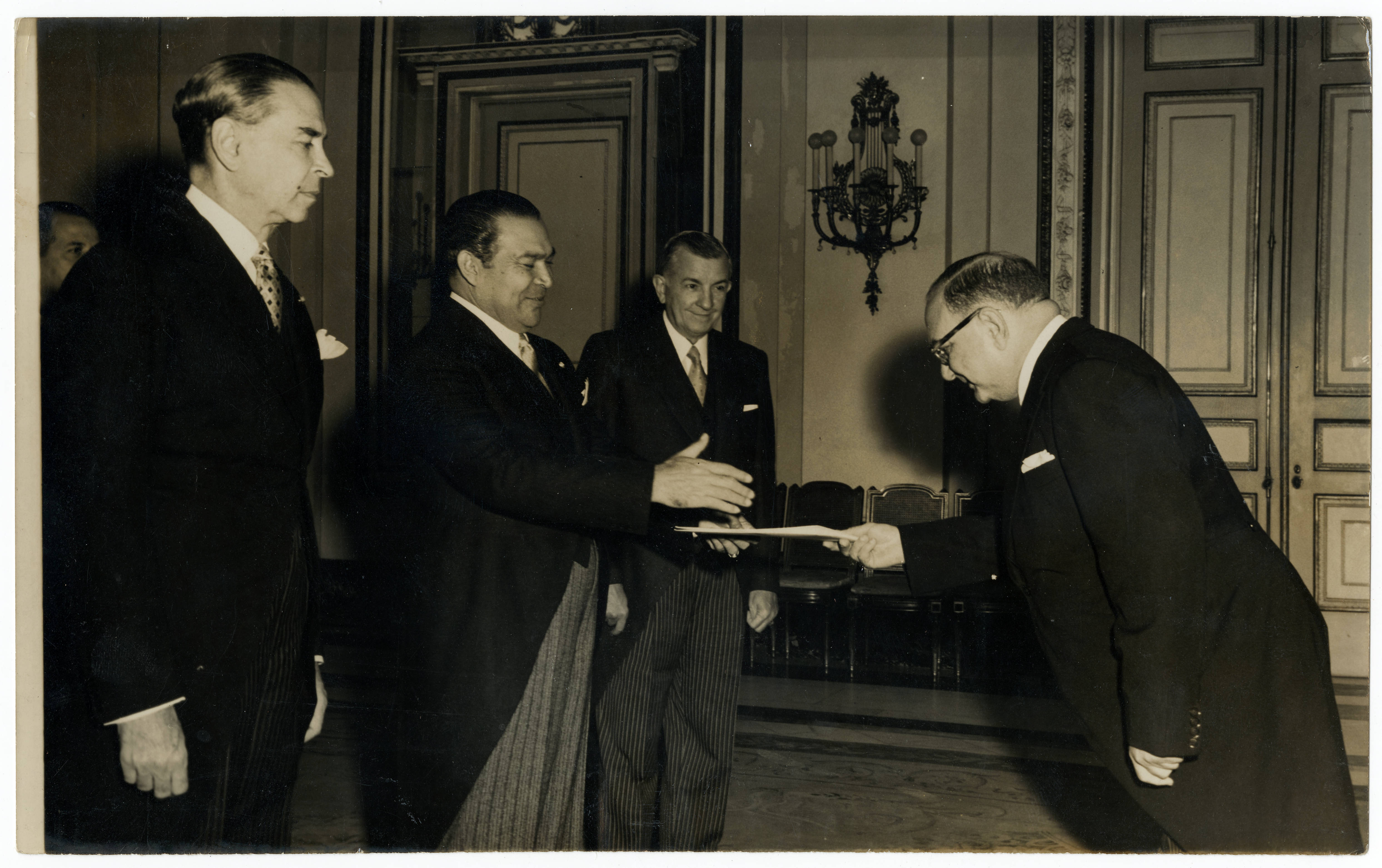 Cuban president Fulgencio Batista about to shake hands with Dominican Ambassador Federico Llaverías — Anónimo