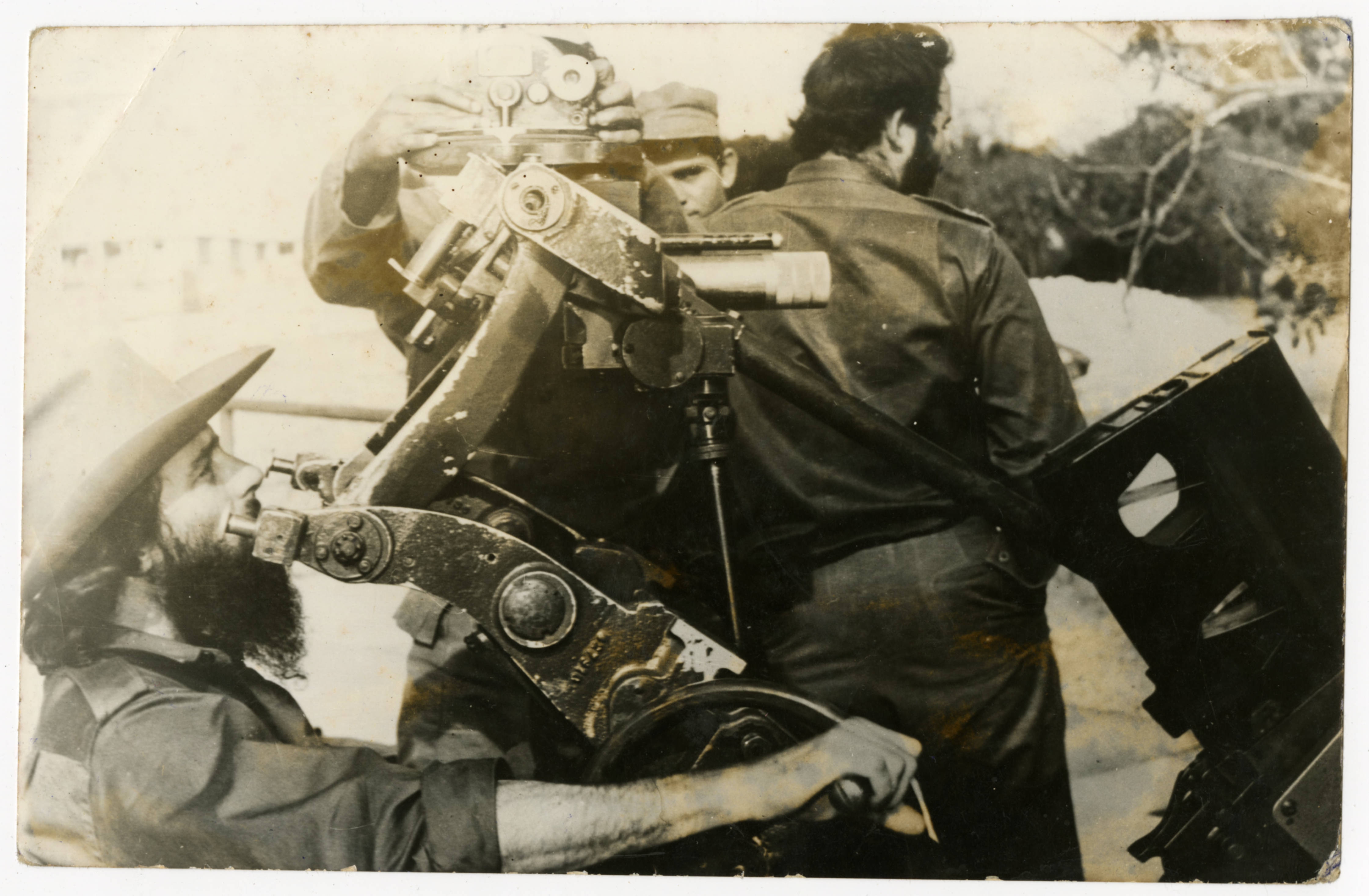 Camilo Cienfuegos (at left) examining a military weapon — Anónimo
