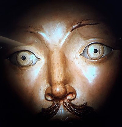 Escultura de Aleijadinho: Rostro con ojos intensos y bigote, luz dramática — Antônio Francisco Lisboa "Aleijadinho"