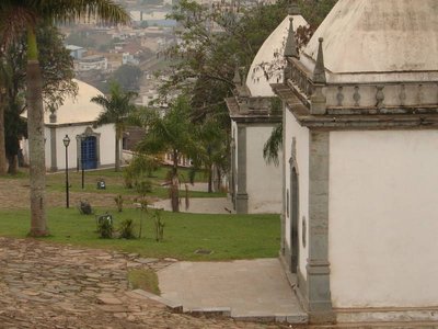 Capillas de cúpulas blancas y piedra entre palmeras y edificios — Antônio Francisco Lisboa "Aleijadinho"